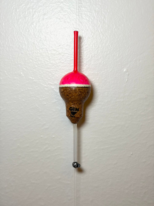 Pink cork fishing slip float attached to a fishing line, on a white background.