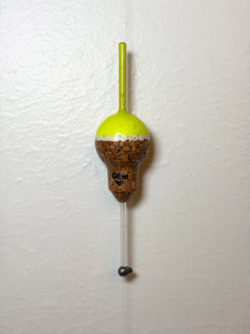 Chartreuse Cork fishing slip float attached to a fishing line, on a white background.