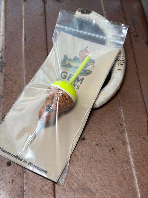 Chartreuse cork fishing slip float, inside plastic bag on an antique tackle box. 