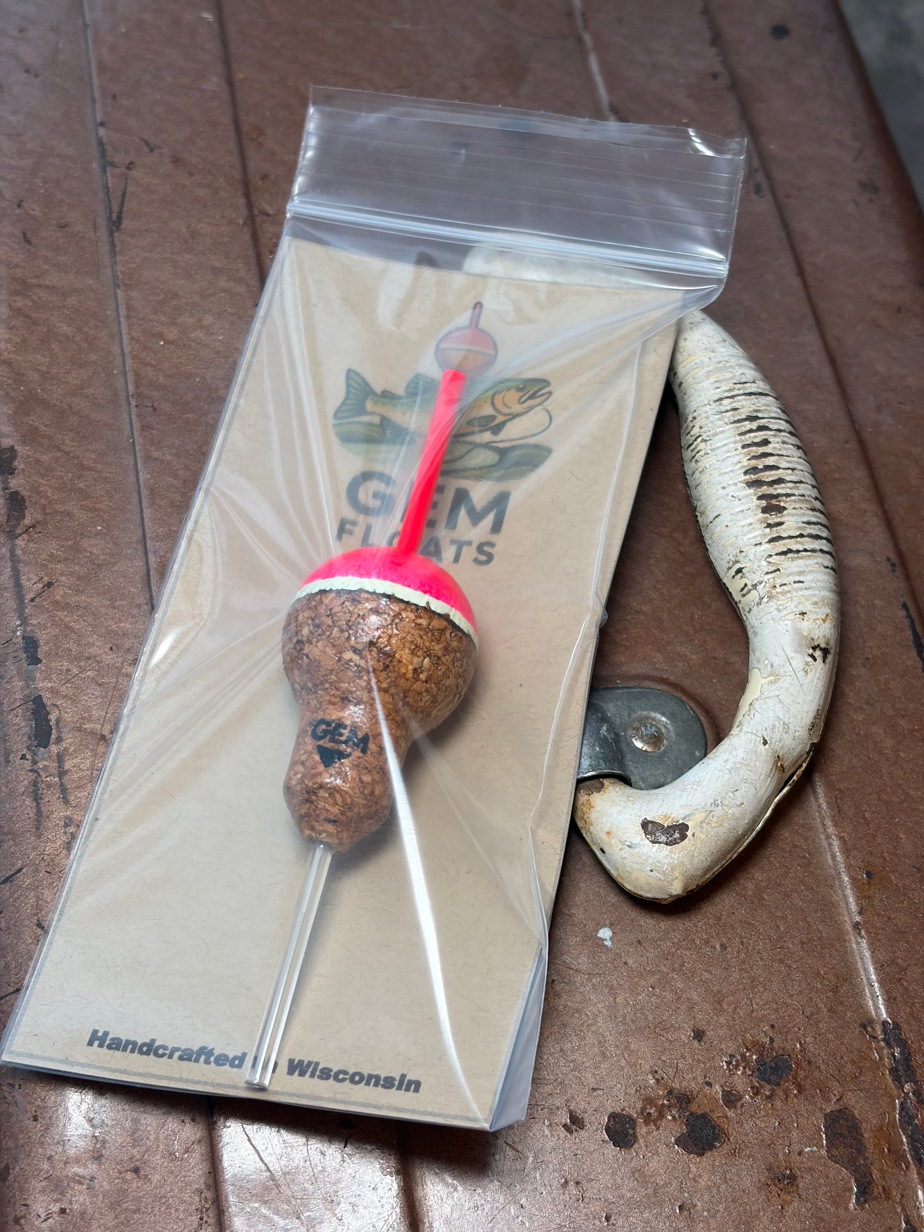 Pink cork fishing slip float, inside plastic bag on an antique tackle box. 