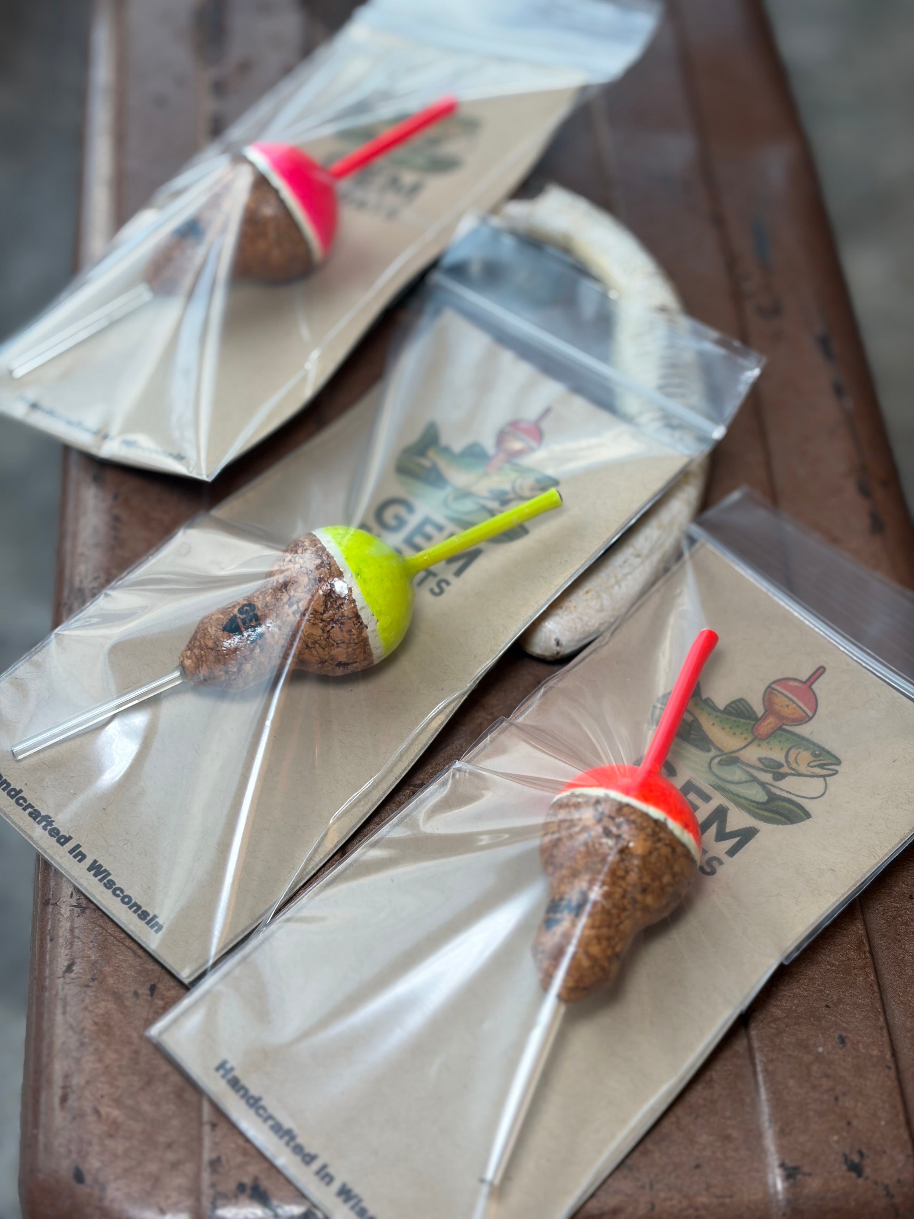 Cork fishing slip floats in plastic bags on an antique tackle box. 
