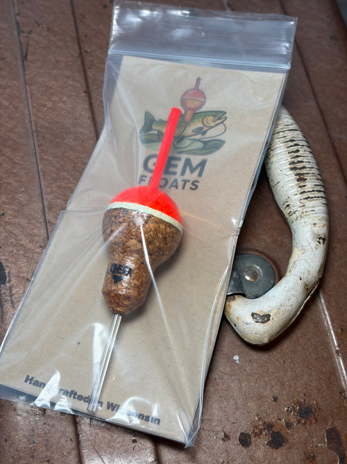 Orange cork fishing slip float, inside plastic bag on an antique tackle box. 